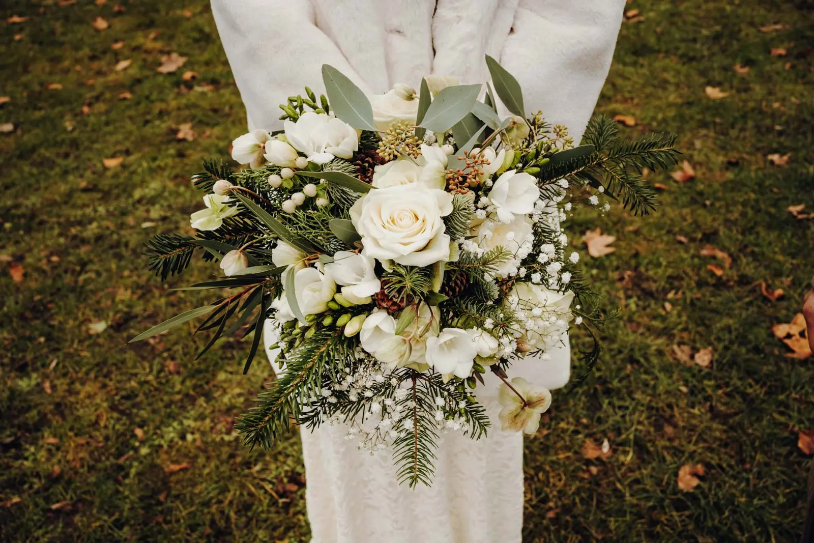Winterlicher Brautstrauss mit weissen Rosen und Tannenzweigen Nahaufnahme des winterlichen Brautstrausses mit weissen Rosen, Schleierkraut, Eukalyptus und Tannenzweigen.
