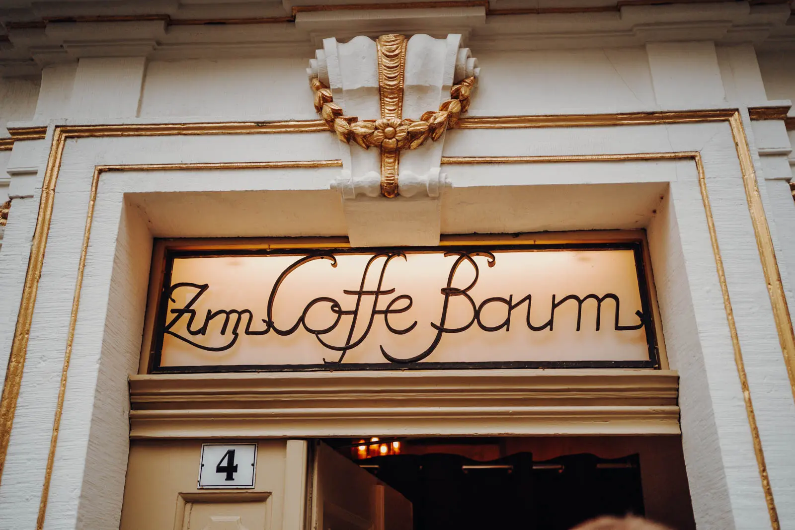 Zum Coffe Baum Leipzig – Eingangstafel Vergoldete Eingangstafel mit Schriftzug Zum Coffe Baum ueber dem historischen Portal des Kaffeehauses in Leipzig.