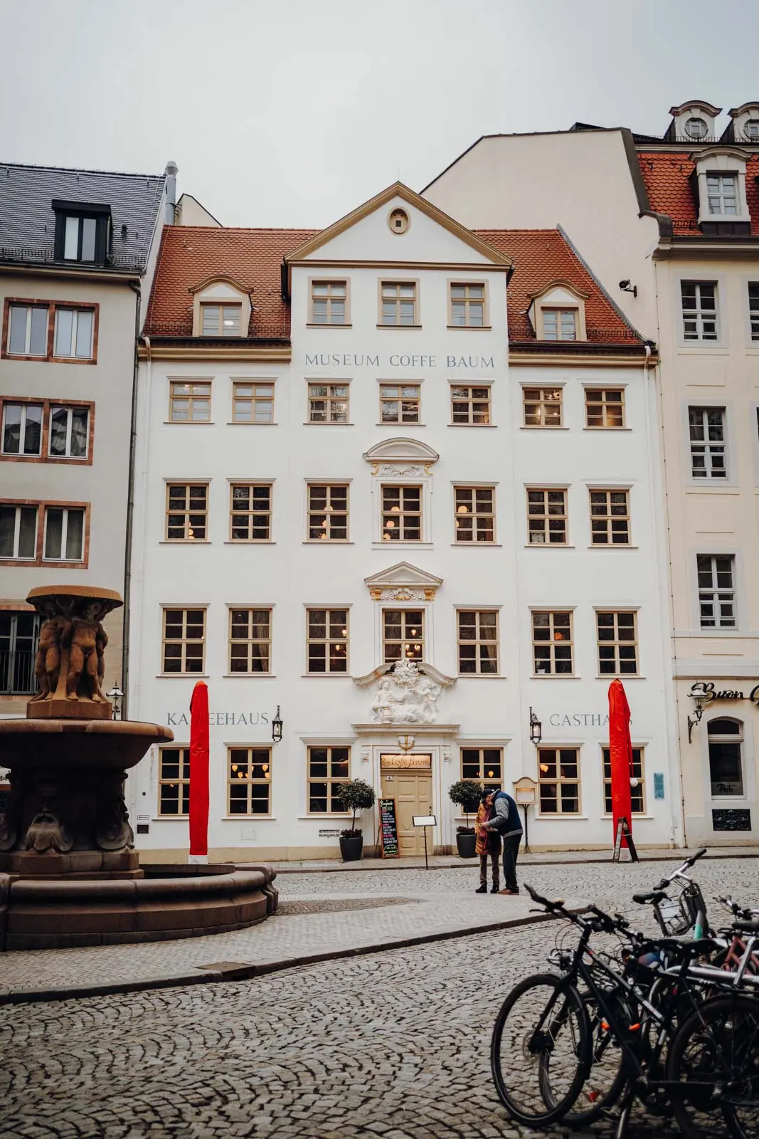 Zum Coffe Baum Leipzig – Fassade mit Brunnen Historische Fassade des Kaffeehauses Zum Coffe Baum in der Leipziger Altstadt mit Brunnen im Vordergrund.