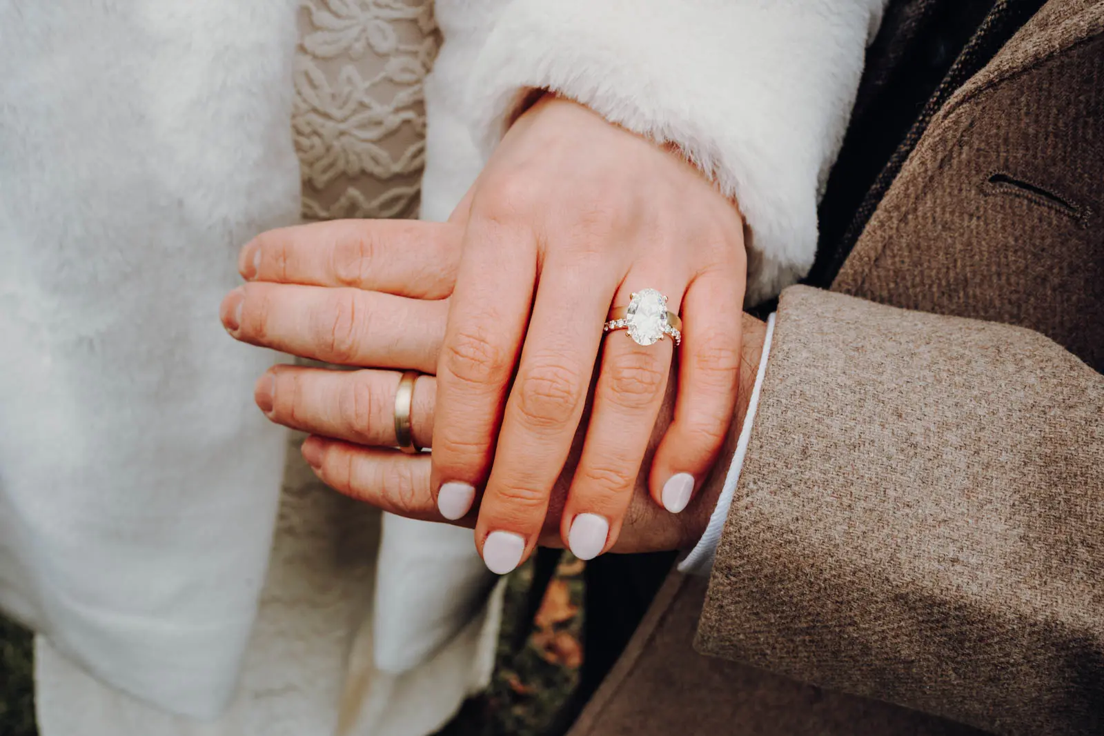 Eheringe nach der Hochzeit am Ratsplenarsaal Leipzig Nahaufnahme der Haende des frisch verheirateten Paares mit Ehering und Verlobungsring mit ovalem Stein.