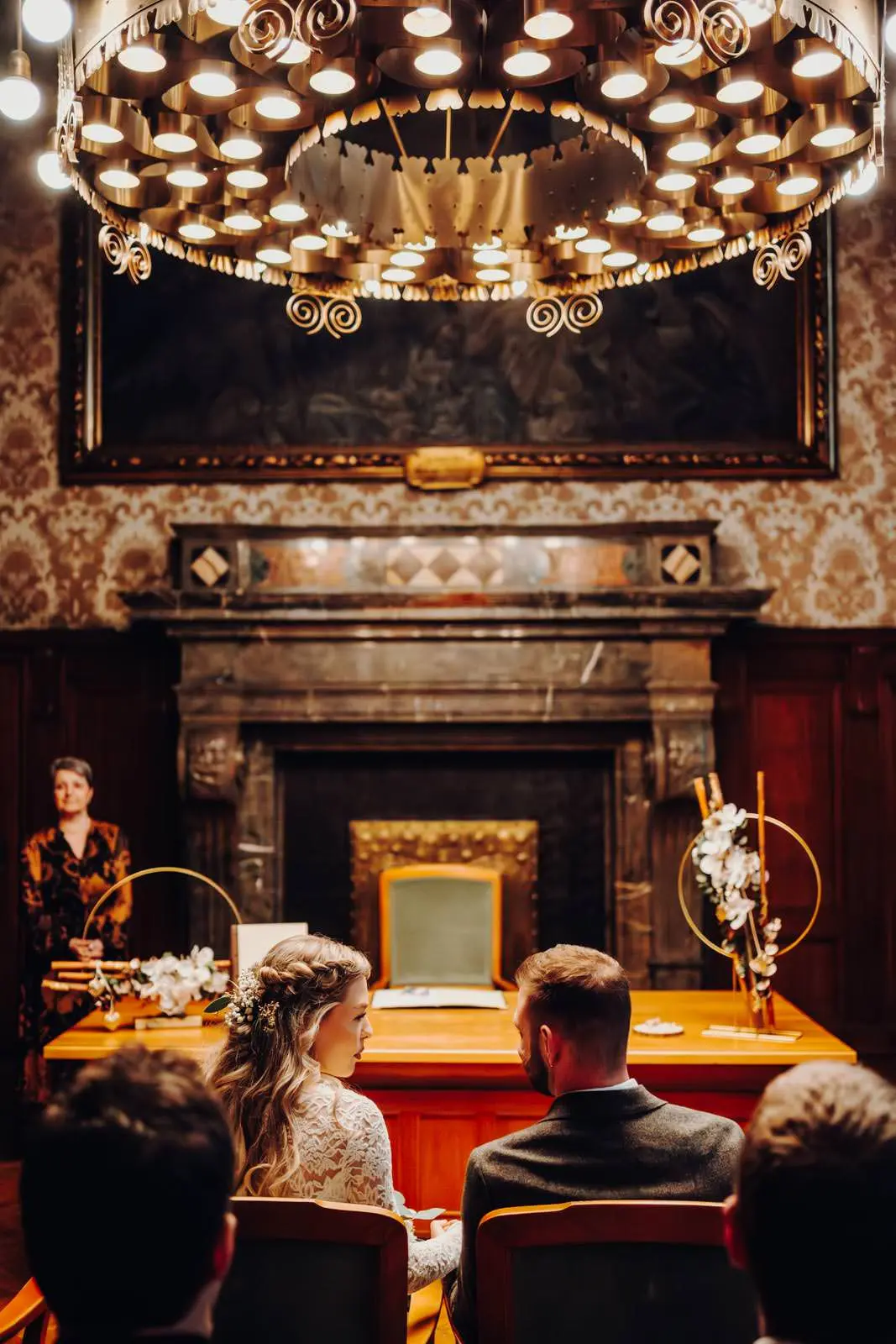 Trauung im Ratsplenarsaal Leipzig – Vogelperspektive Hochzeit im Ratsplenarsaal Leipzig von oben, Brautpaar vor dem Trautisch unter dem goldenen Kronleuchter mit Kamin und Gemalde im Hintergrund.