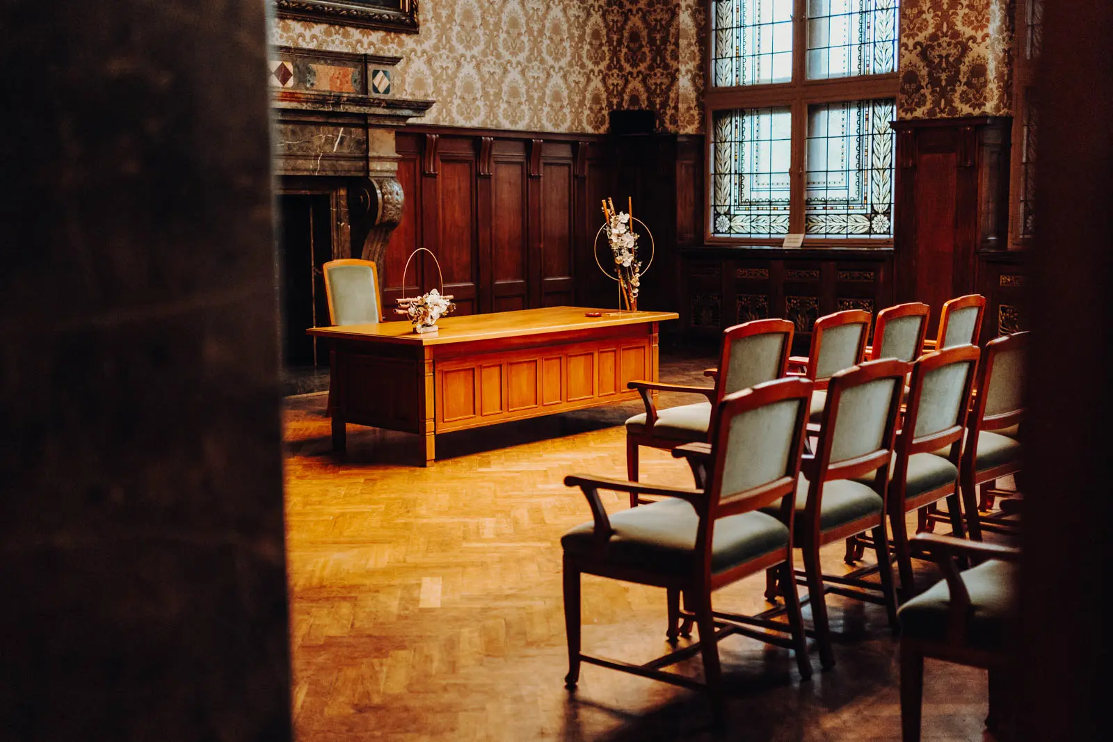 Trauzimmer Rathaus Leipzig – Schreibtisch und Deko Holzgetaefeltes Trauzimmer im Neuen Rathaus Leipzig mit Schreibtisch, Blumenring-Deko und bleiverglasten Fenstern. Hochzeit Ratsplenarsaal Leipzig